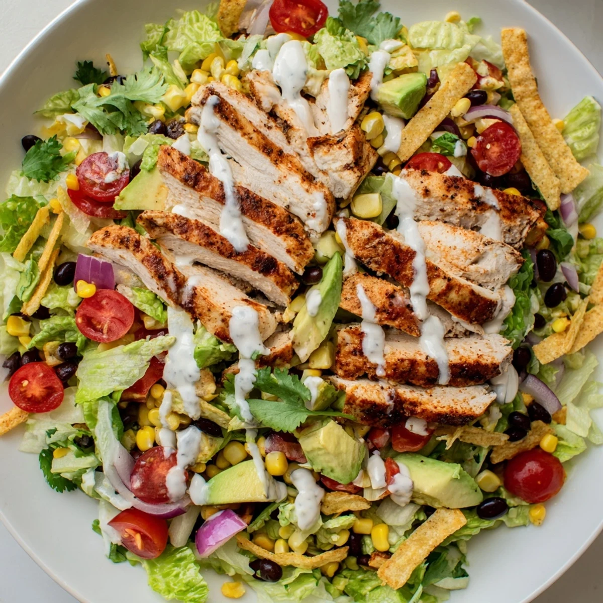 Hearty Southwestern chicken salad plated with juicy seasoned grilled chicken, colorful mixed vegetables, tangy creamy dressing and fresh cilantro for a satisfying gluten-free meal