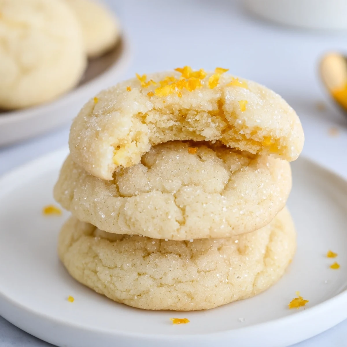 Soft Chewy Lemon Cookies rolled in sugar, cooling on parchment-lined sheet