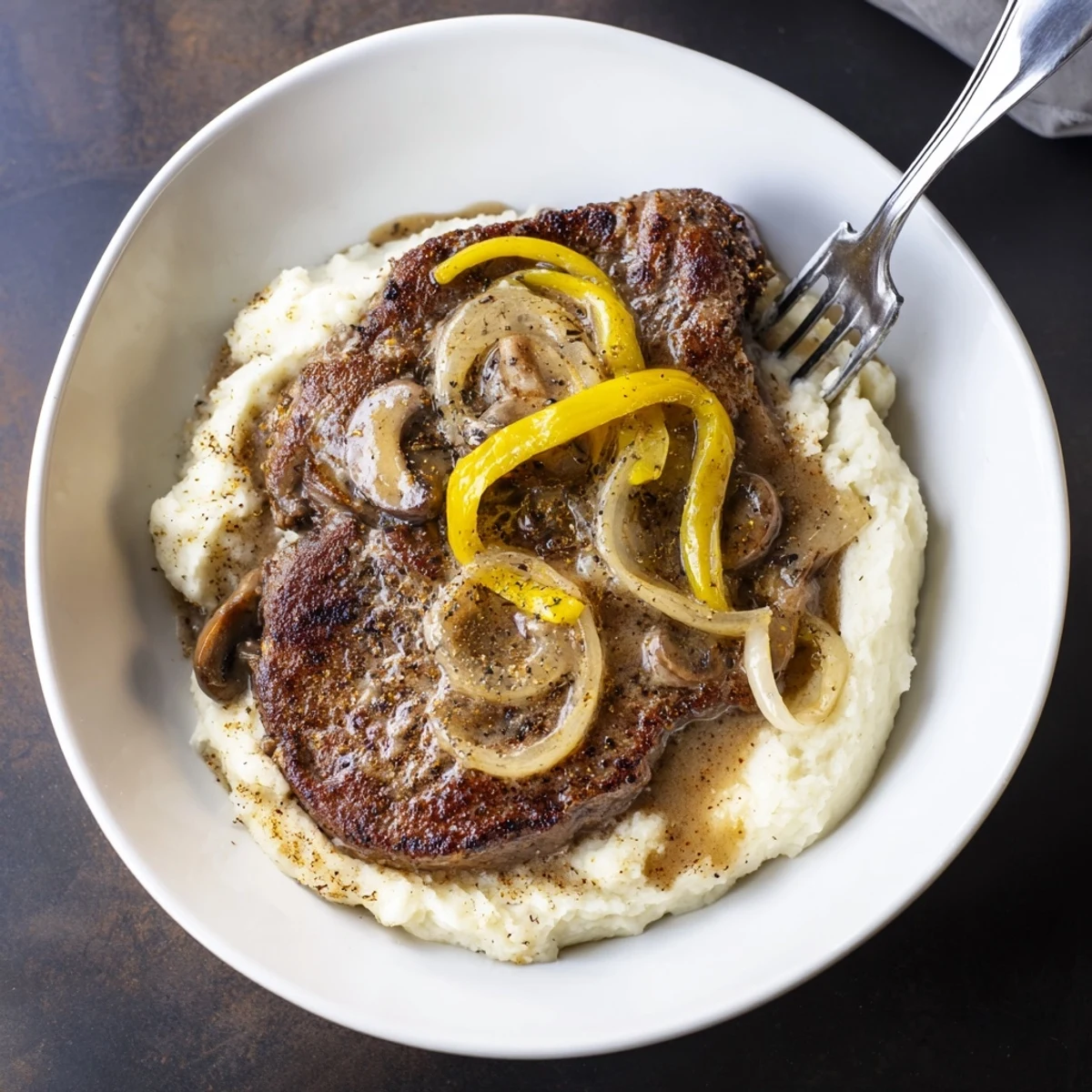 Country Style Smothered Cube Steak Recipe simmered in skillet, served over creamy rice