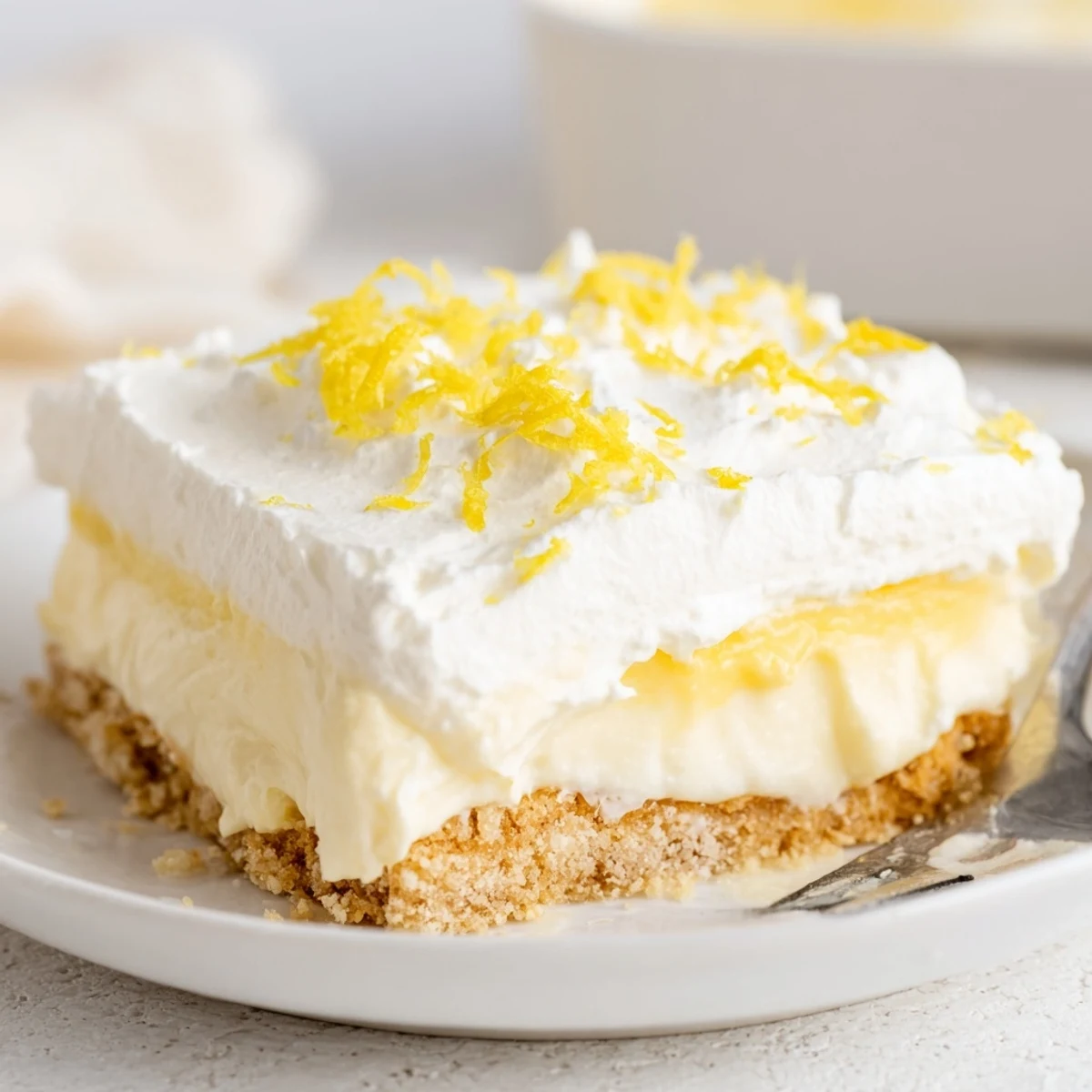 Chilled Lemon Lush Cake layered on cookie crust, creamy lemon filling