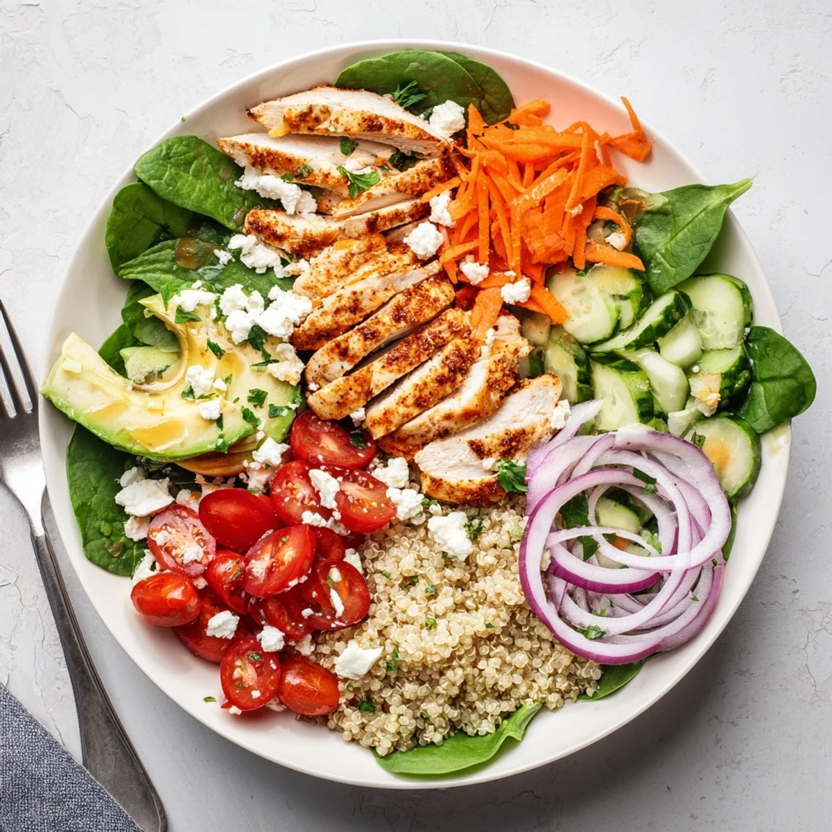 Colorful chicken grain bowl with fresh vegetables and zesty lemon dressing