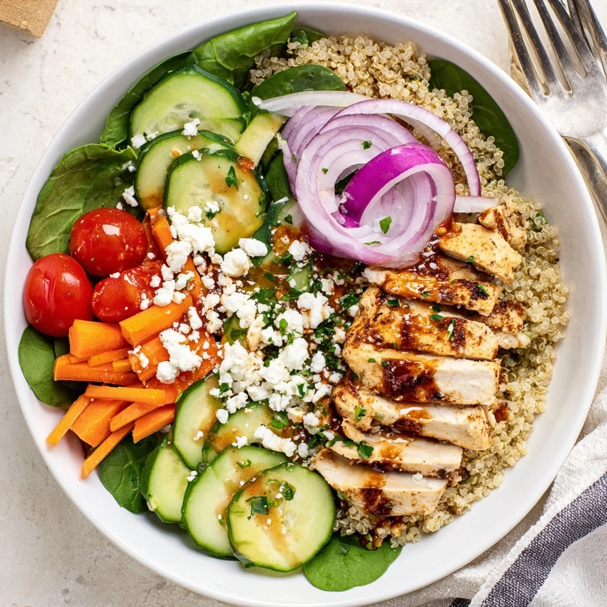 Warm smoked paprika chicken grain bowl served over fluffy quinoa with herbs