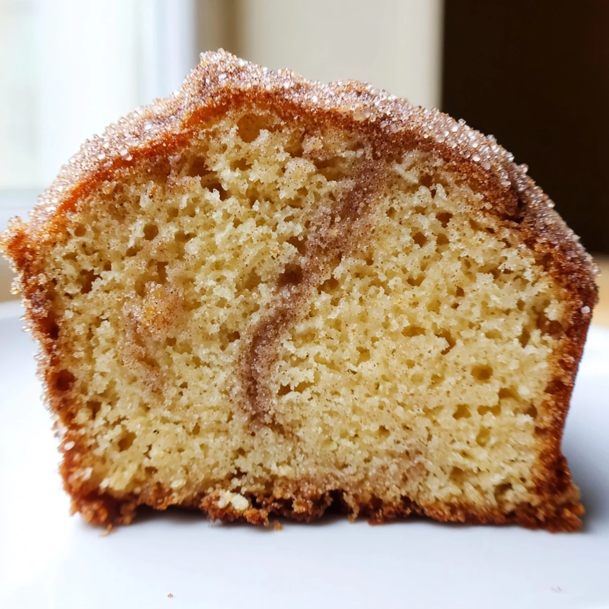Golden cinnamon donut loaf sliced thick on a rustic wooden cutting board