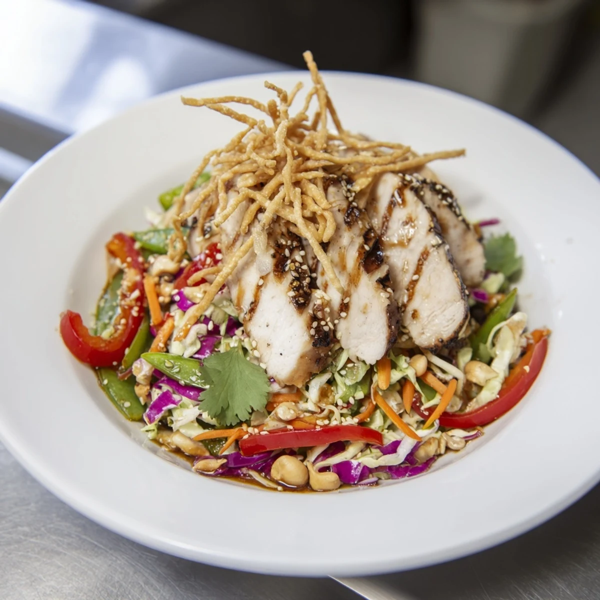 Fresh chicken cashew crunch salad topped with crispy wontons snap peas and a tangy soy-sesame drizzle