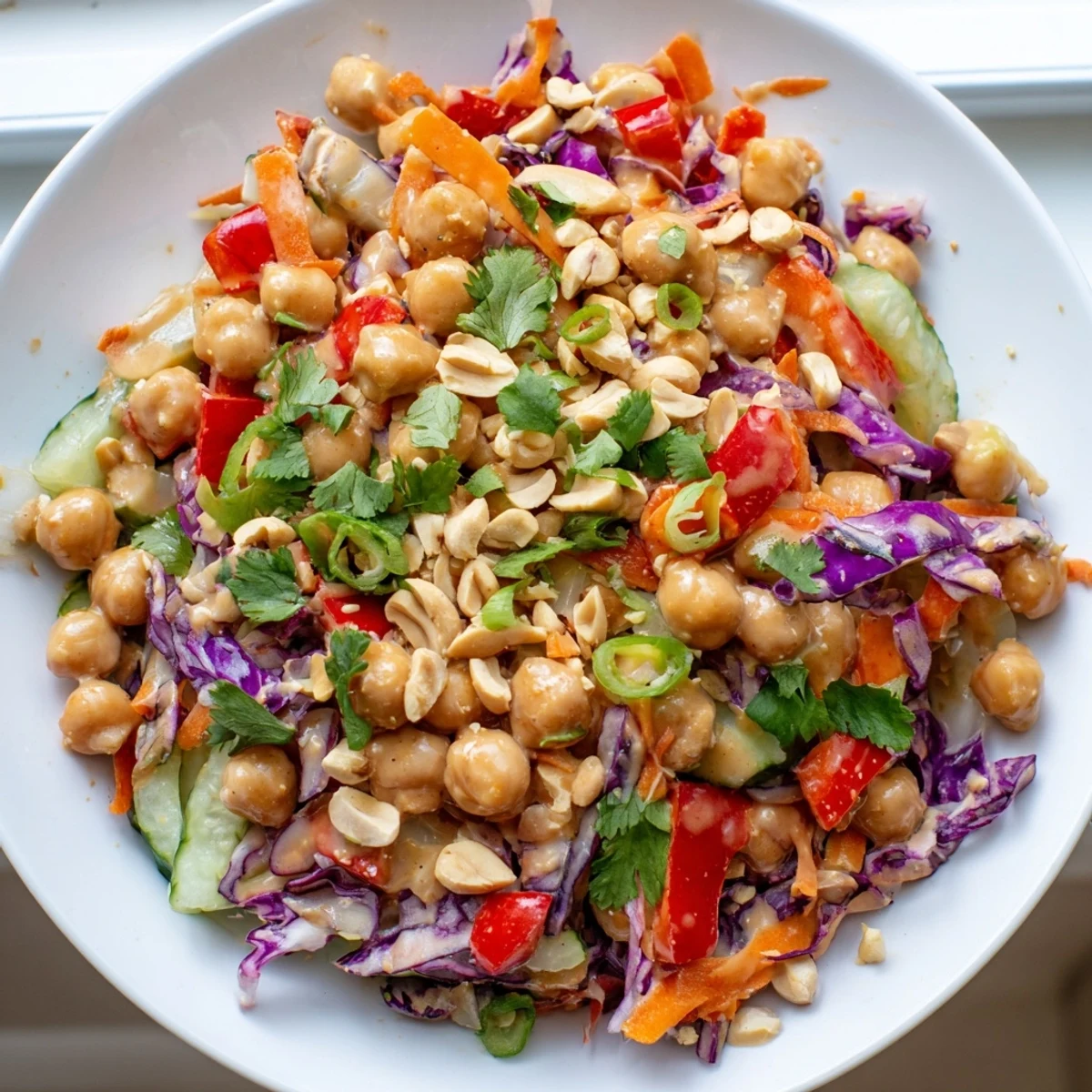 Crunchy Thai chickpea salad tossed in creamy peanut dressing with colorful vegetables