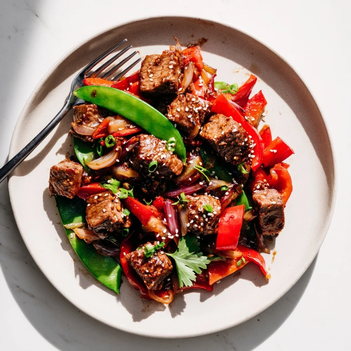 Juicy pan-seared Asian-inspired cube steak served over vibrant bell pepper and snap pea stir-fry