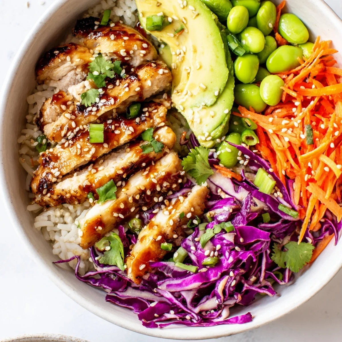 Colorful Asian Inspired Chicken Power Bowl with fresh vegetables and sesame dressing