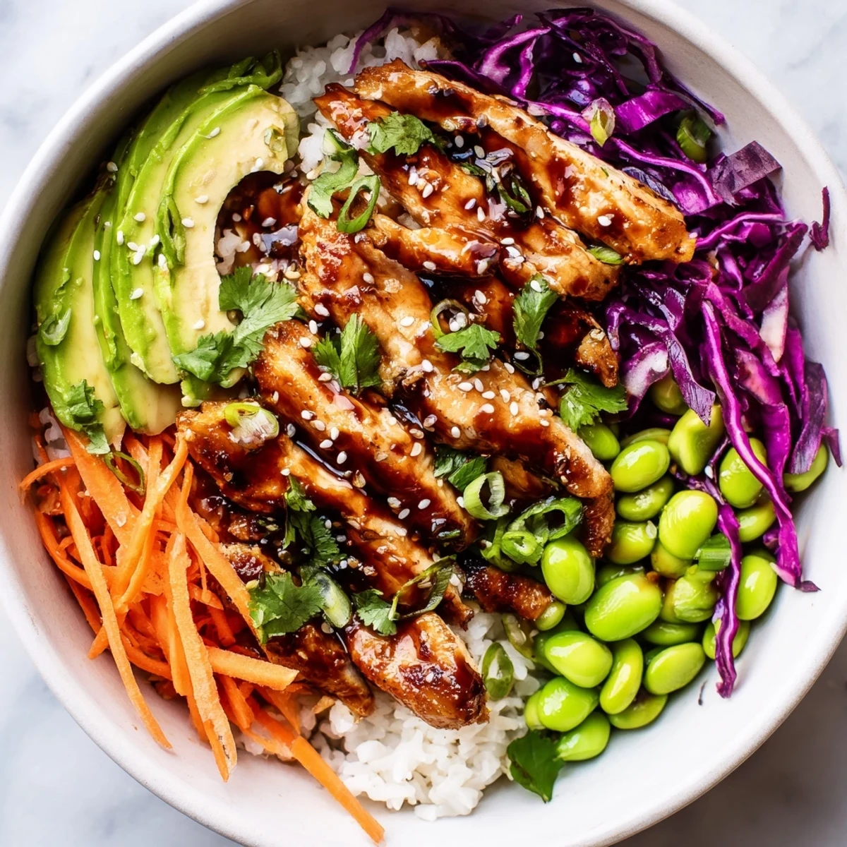 Golden marinated chicken strips over rice with crisp veggies in a vibrant bowl