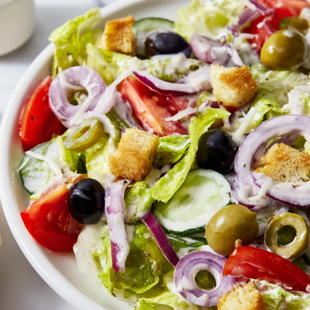Fresh romaine Olive Garden salad topped with pepperoncini, black olives, and tangy vinaigrette