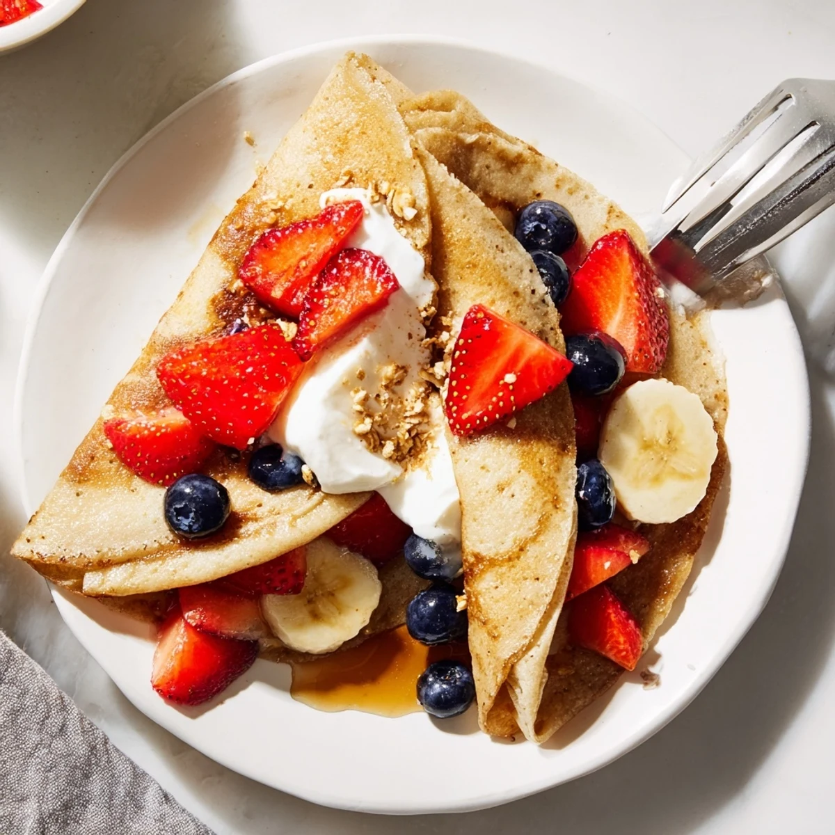 Soft pancake tacos topped with blueberries and Greek yogurt served on a rustic platter