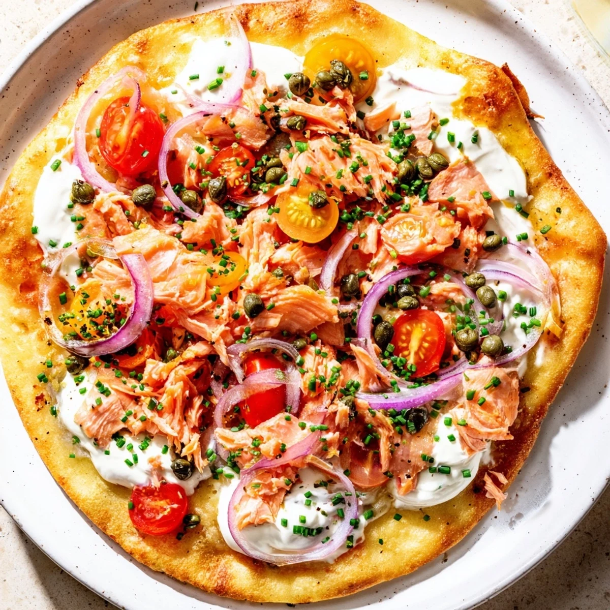 Easy homemade salmon tortilla pizza garnished with fresh dill and served with lemon wedges