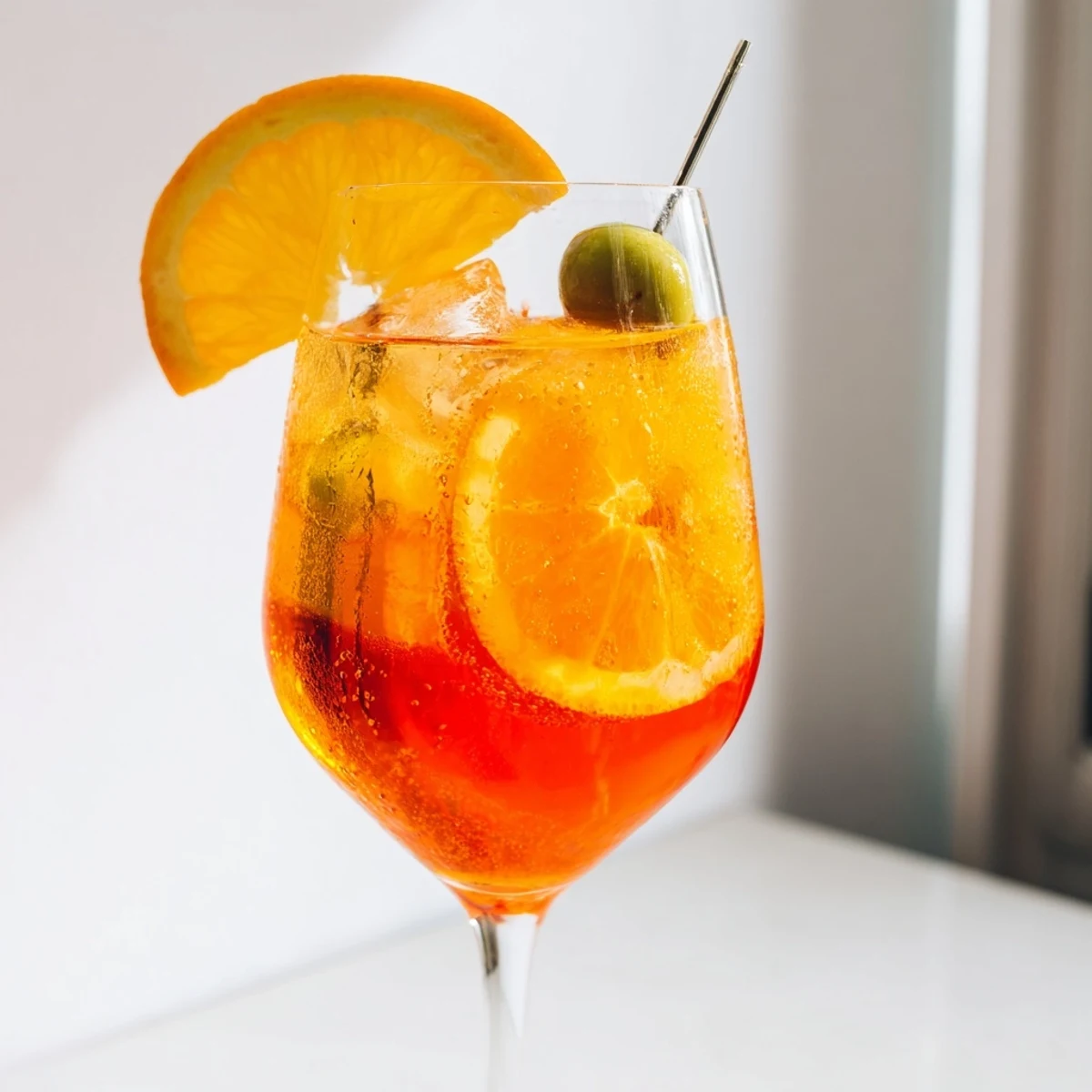 Refreshing Italian Spritz poured over ice with a zesty orange twist and olive  