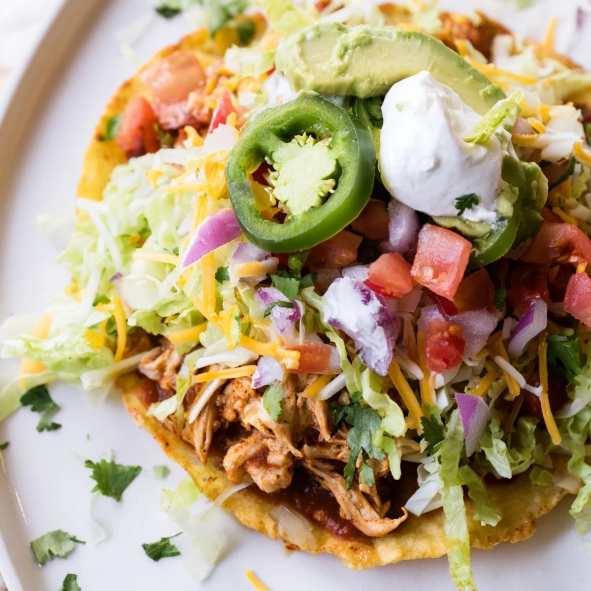 Golden crispy Chicken Tostadas piled high with fresh toppings and melty cheese  