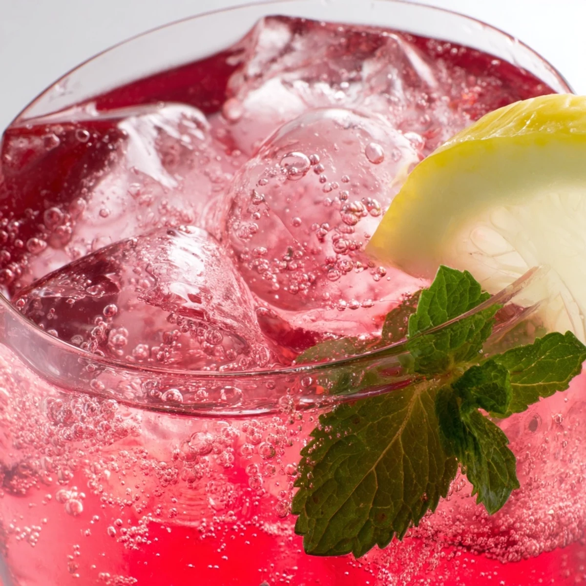 Vibrant honey lemon pink soda garnished with fresh mint and lemon slices  