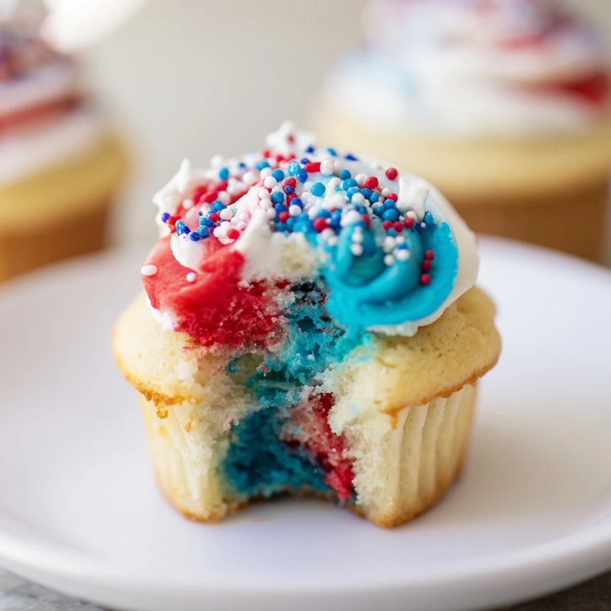 Festive July Tie Dye Cupcakes topped with vibrant red, white, and blue swirls.  