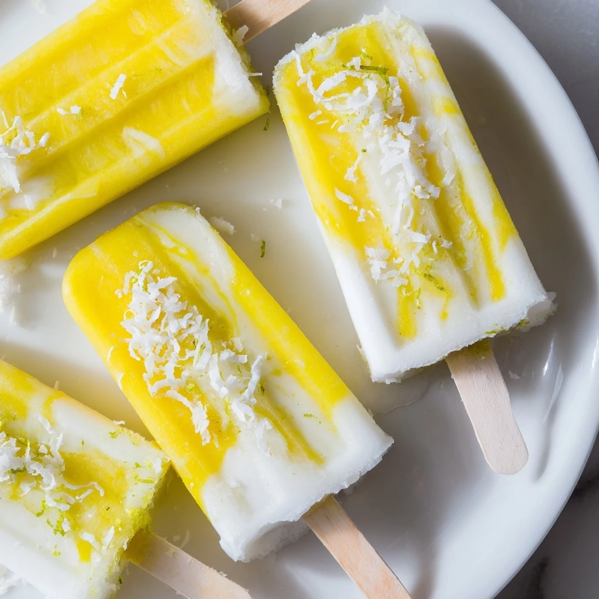 Vegan pineapple coconut lime popsicles in a mold, showcasing sweet fruit and creamy coconut milk.