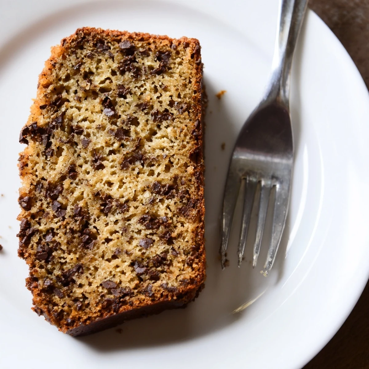 Golden slice of moist one bowl banana bread with melting chocolate chips