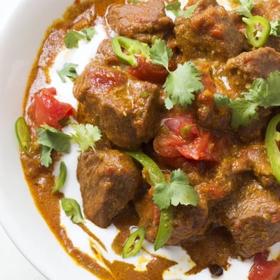 Spicy Beef Curry with Basmati Rice steams in a rustic pot, showcasing rich golden spices and tender meat ready to be served.