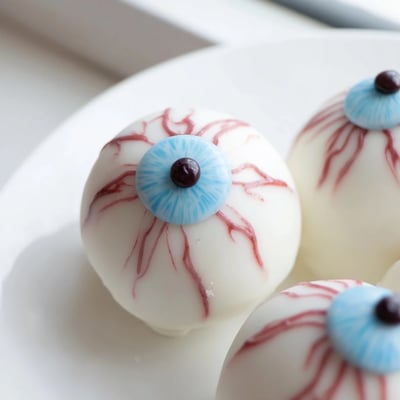 Close-up of glossy Halloween Cake Eyeballs featuring dark chocolate pupils and creepy bloodshot details