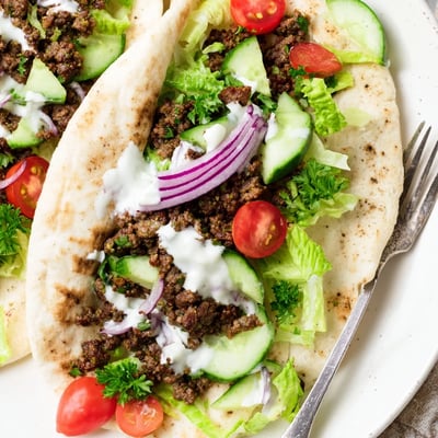 Warm pita bread filled with spiced Mediterranean ground beef and crisp colorful vegetables.